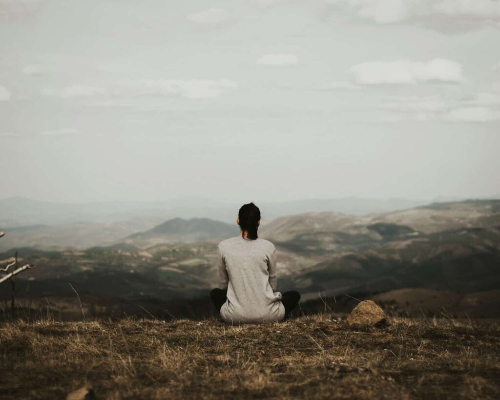 woman enjoying a beautiful view of mountains during a time of personal retreat